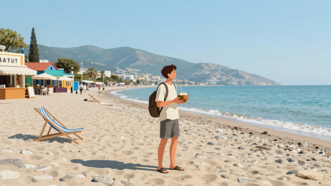 Путешественник на пляже в Батуми с кокосовым соком и каменистым берегом.